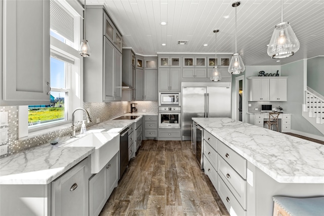 kitchen featuring dark hardwood / wood-style floors, hanging light fixtures, gray cabinetry, stainless steel appliances, and a large island