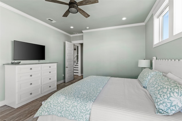 bedroom with ornamental molding, hardwood / wood-style floors, and ceiling fan