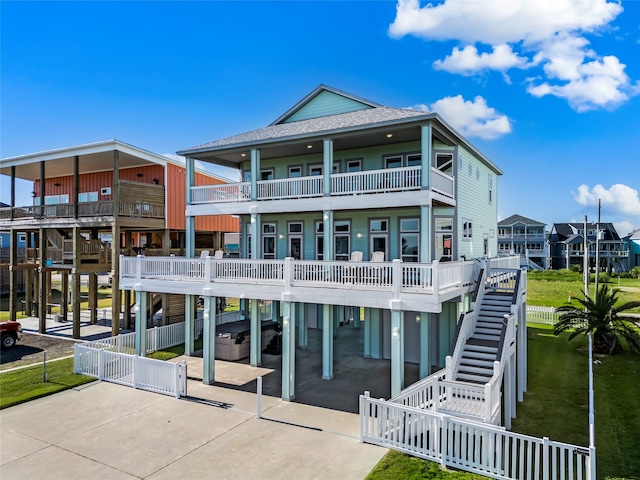 rear view of house featuring a yard, a carport, and a balcony