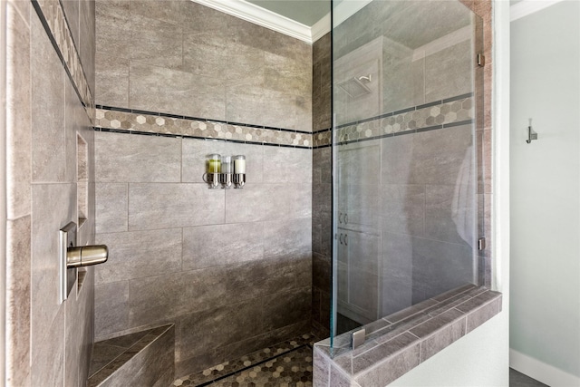 full bathroom with crown molding and a tile shower
