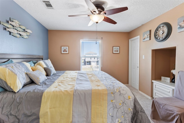 bedroom featuring a textured ceiling, carpet flooring, and ceiling fan