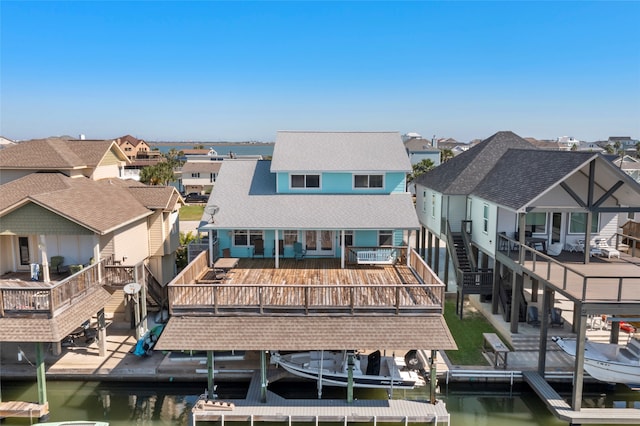 rear view of house featuring a deck with water view