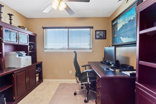 office area with light colored carpet, baseboards, and a ceiling fan