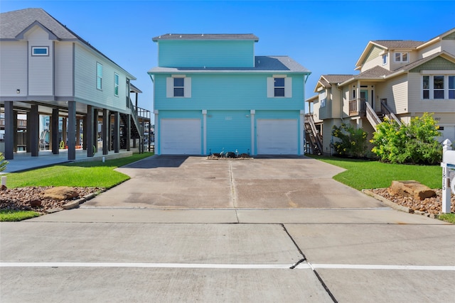 view of front of home featuring a front yard, a garage, driveway, and stairs