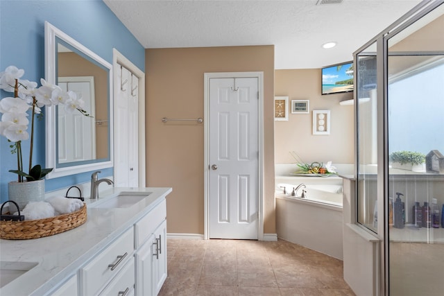 bathroom with vanity, independent shower and bath, a textured ceiling, and tile patterned floors