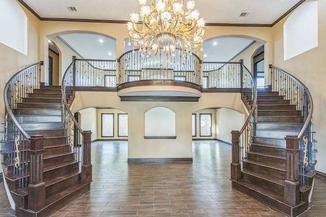 interior space featuring a high ceiling, crown molding, a chandelier, and dark hardwood / wood-style floors