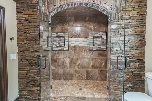 bathroom with walk in shower and toilet