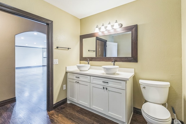 bathroom with wood-type flooring, vanity, and toilet