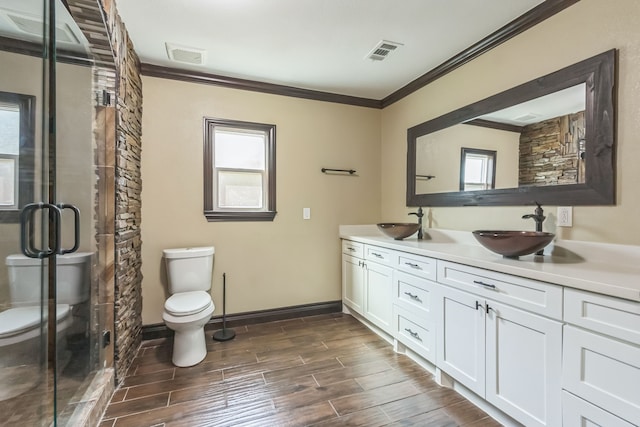 bathroom with vanity, toilet, crown molding, hardwood / wood-style floors, and a shower with door