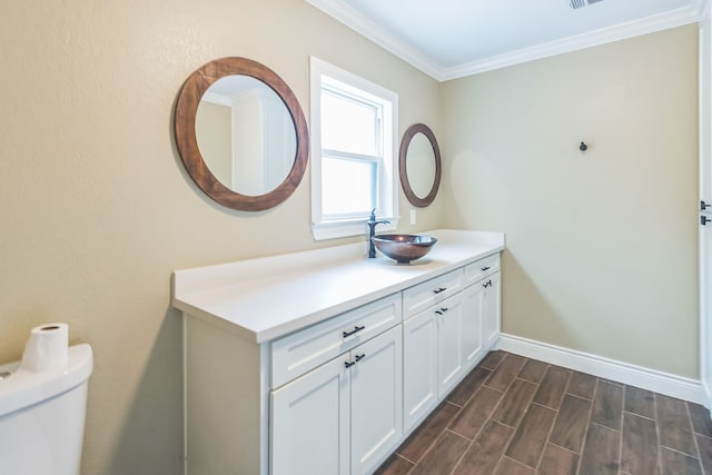 bathroom featuring hardwood / wood-style flooring, crown molding, vanity, and toilet