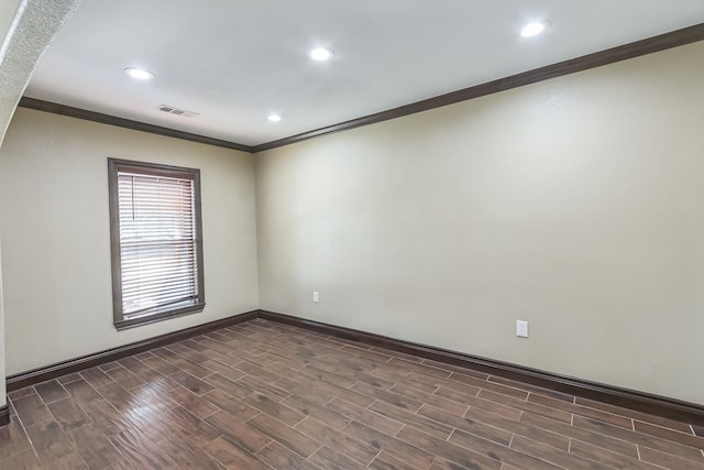 empty room with crown molding and dark hardwood / wood-style flooring