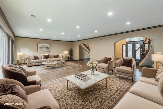 living room with crown molding and hardwood / wood-style floors