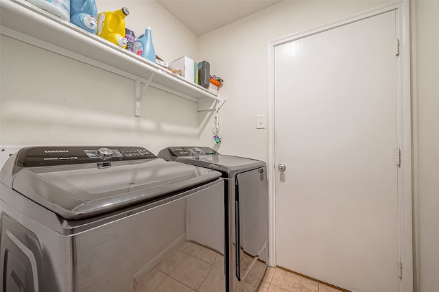 laundry room featuring washing machine and dryer and light tile patterned floors