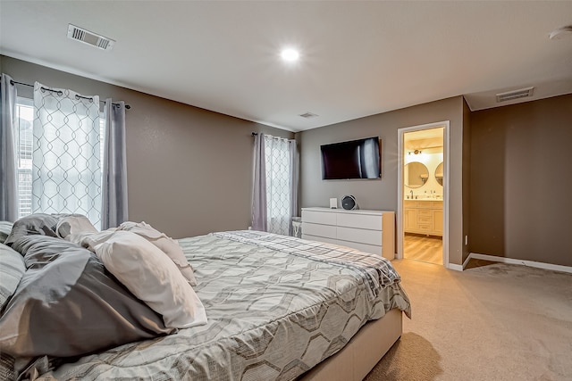 carpeted bedroom featuring connected bathroom and multiple windows