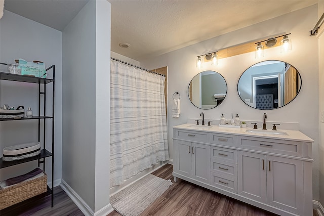 bathroom featuring vanity, a textured ceiling, curtained shower, and wood-type flooring