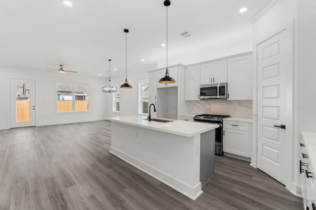 kitchen featuring white cabinets, a kitchen island with sink, appliances with stainless steel finishes, and sink