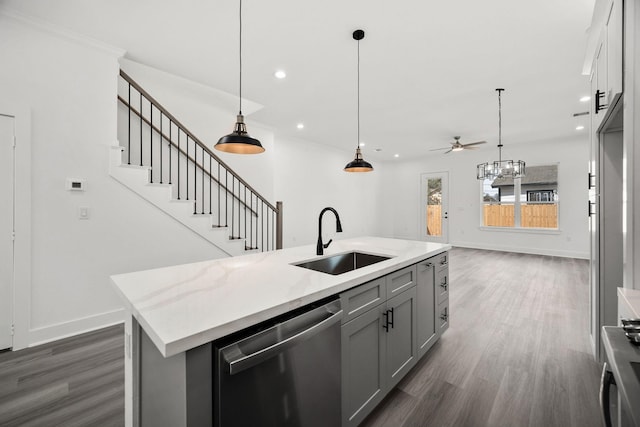 kitchen with sink, hanging light fixtures, gray cabinets, stainless steel dishwasher, and a center island with sink