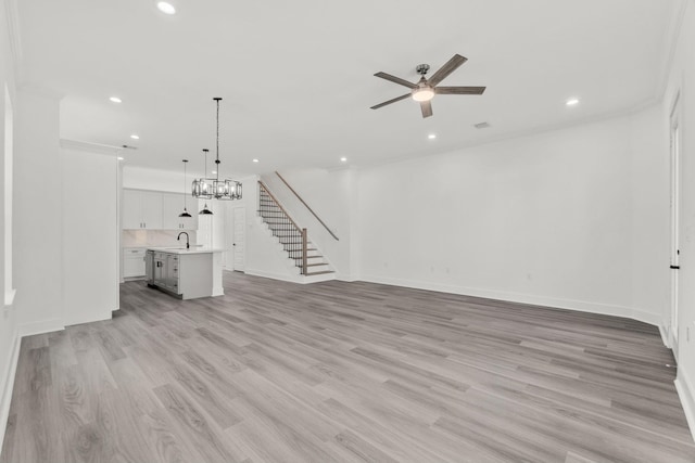 unfurnished living room featuring ceiling fan with notable chandelier, sink, light hardwood / wood-style flooring, and crown molding