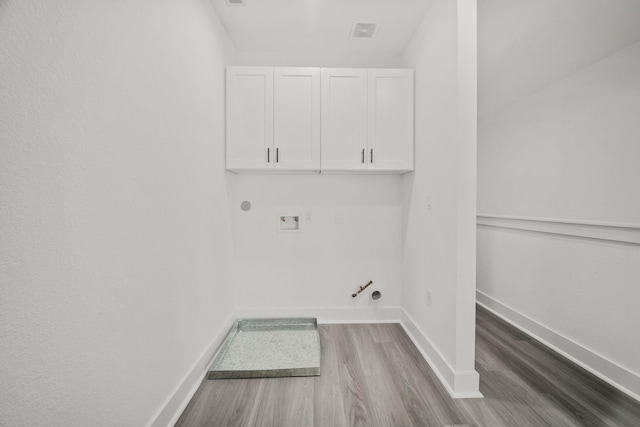 washroom featuring hookup for a gas dryer, wood-type flooring, washer hookup, and cabinets