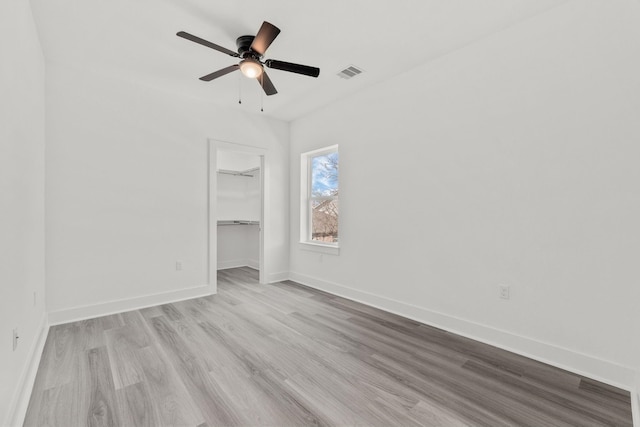 unfurnished bedroom with ceiling fan, a closet, and light hardwood / wood-style floors