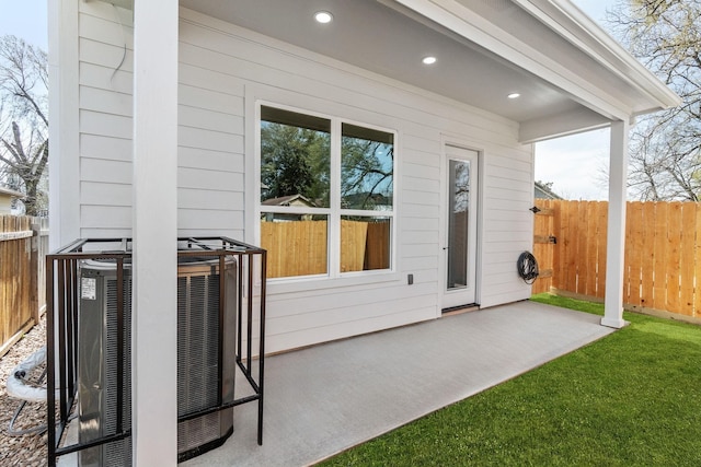 exterior space with central AC unit, a yard, and a patio