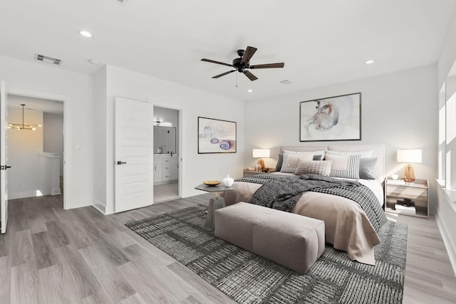 bedroom featuring ceiling fan, ensuite bath, and light wood-type flooring