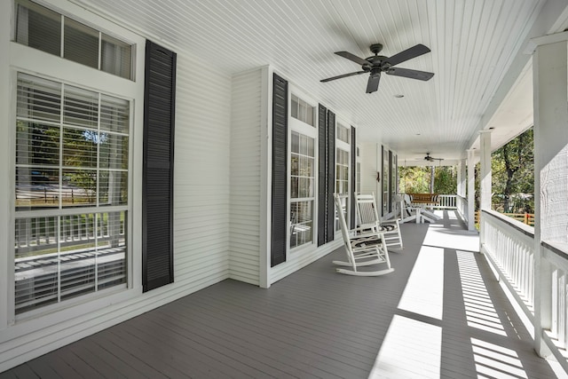 wooden deck featuring covered porch and ceiling fan