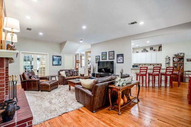 living room with a fireplace and light wood-type flooring