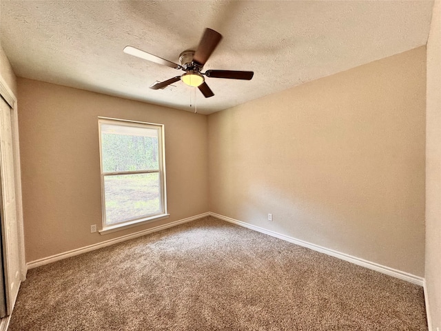 carpeted spare room featuring ceiling fan and a textured ceiling