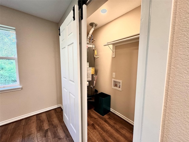 laundry area featuring water heater, dark wood-type flooring, and washer hookup