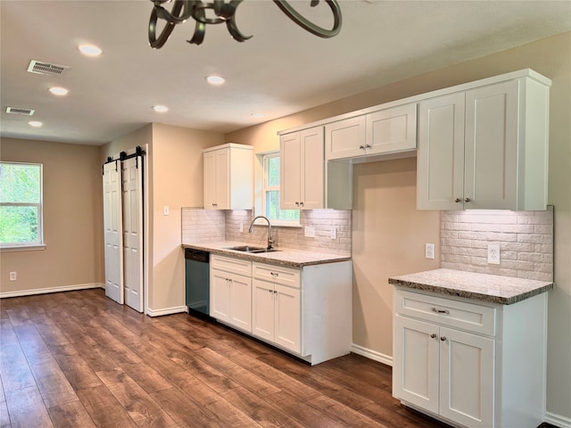 kitchen featuring dark wood-type flooring, sink, a barn door, white cabinetry, and plenty of natural light