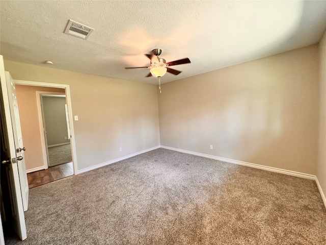 empty room with a textured ceiling, carpet floors, and ceiling fan