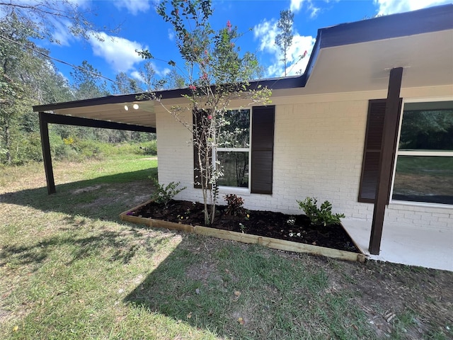 view of home's exterior featuring a carport and a yard