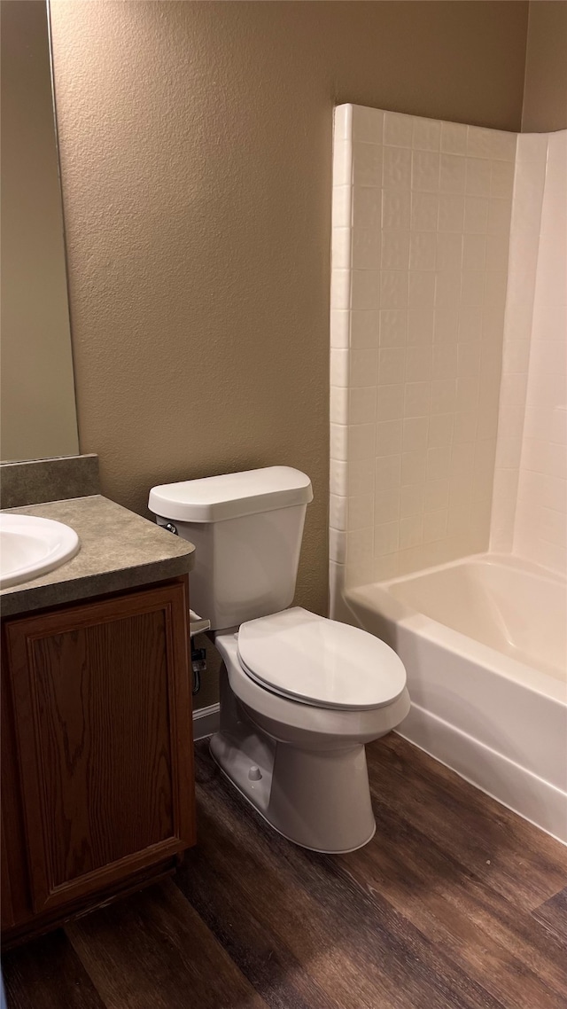 full bathroom with hardwood / wood-style flooring, vanity, toilet, and  shower combination