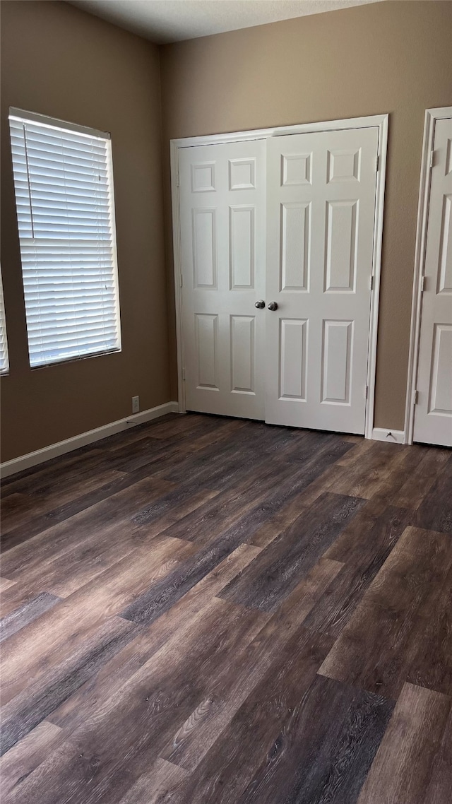 unfurnished bedroom with dark hardwood / wood-style floors