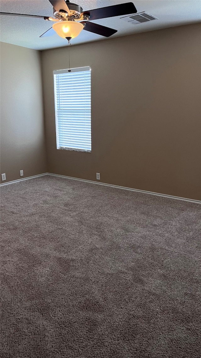 spare room with ceiling fan, a textured ceiling, and carpet flooring