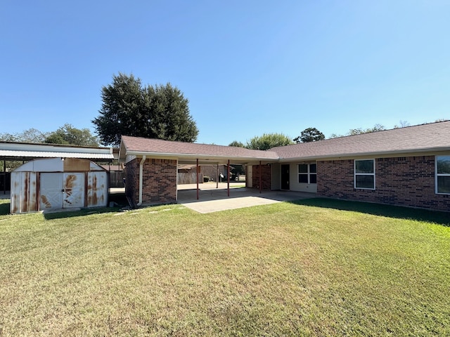 rear view of house with a patio area, a storage unit, and a lawn