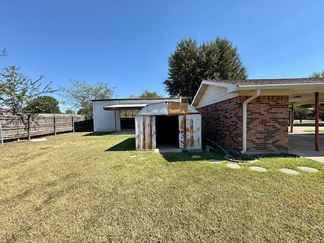 back of house with a storage shed and a lawn