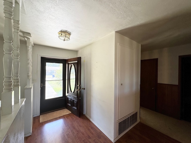 foyer entrance featuring a textured ceiling and dark hardwood / wood-style flooring