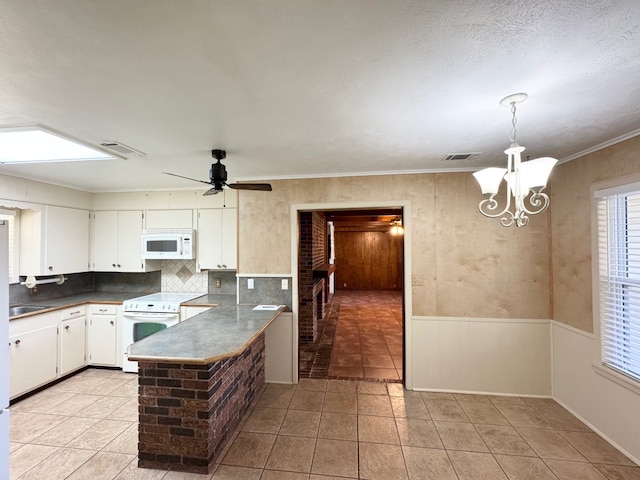 kitchen featuring white cabinets, kitchen peninsula, white appliances, ceiling fan with notable chandelier, and decorative backsplash