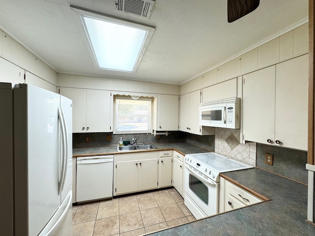 kitchen with white cabinets, a skylight, and white appliances