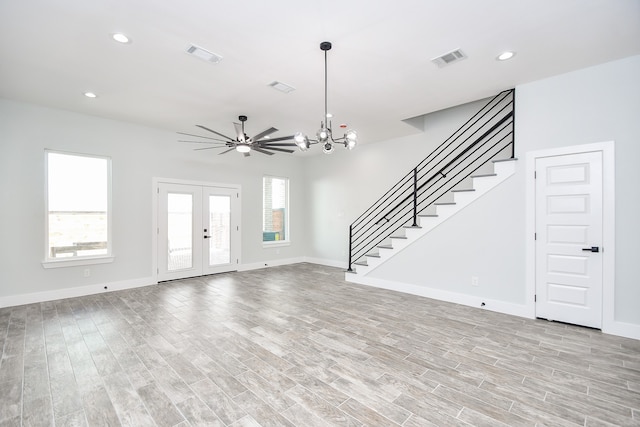 entrance foyer with french doors, light hardwood / wood-style flooring, plenty of natural light, and ceiling fan with notable chandelier