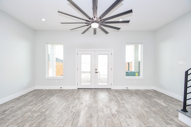 foyer featuring french doors, ceiling fan, and light wood-type flooring