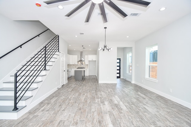 unfurnished living room with light hardwood / wood-style floors and an inviting chandelier