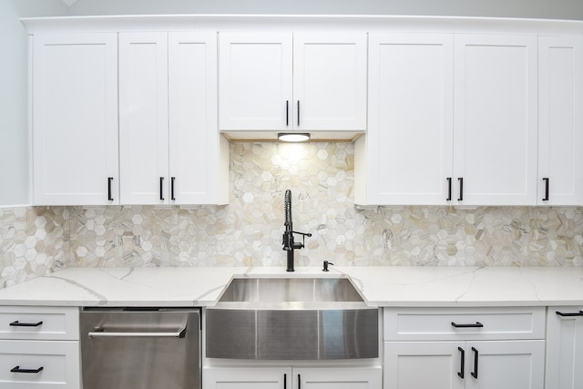 kitchen featuring white cabinetry, light stone counters, sink, and backsplash