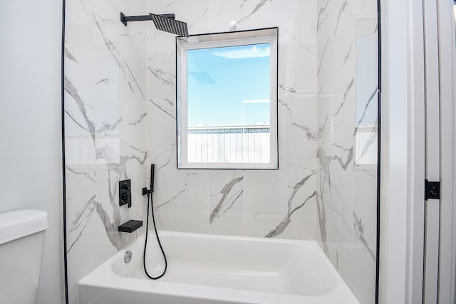 bathroom with toilet and tiled shower / bath