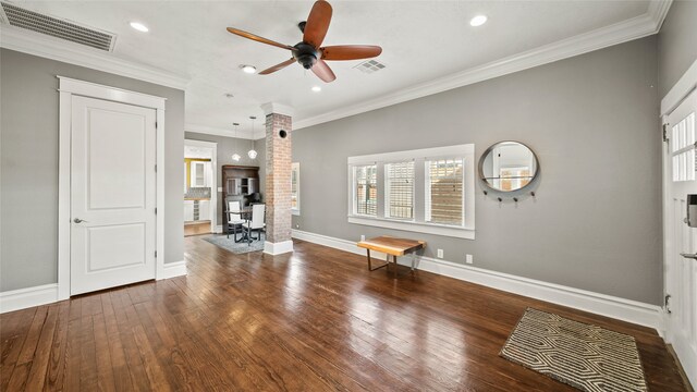 entrance foyer featuring ornamental molding, a healthy amount of sunlight, and dark wood-type flooring