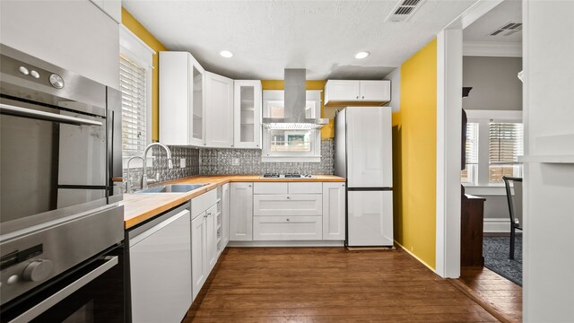 kitchen with decorative backsplash, dark hardwood / wood-style flooring, sink, stainless steel appliances, and white cabinets