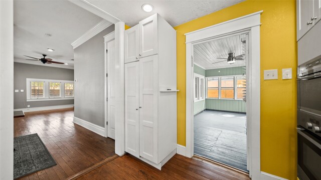 hallway featuring dark wood-type flooring and ornamental molding