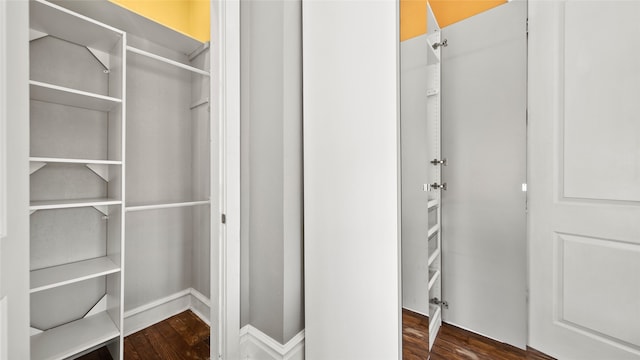 walk in closet with dark hardwood / wood-style flooring